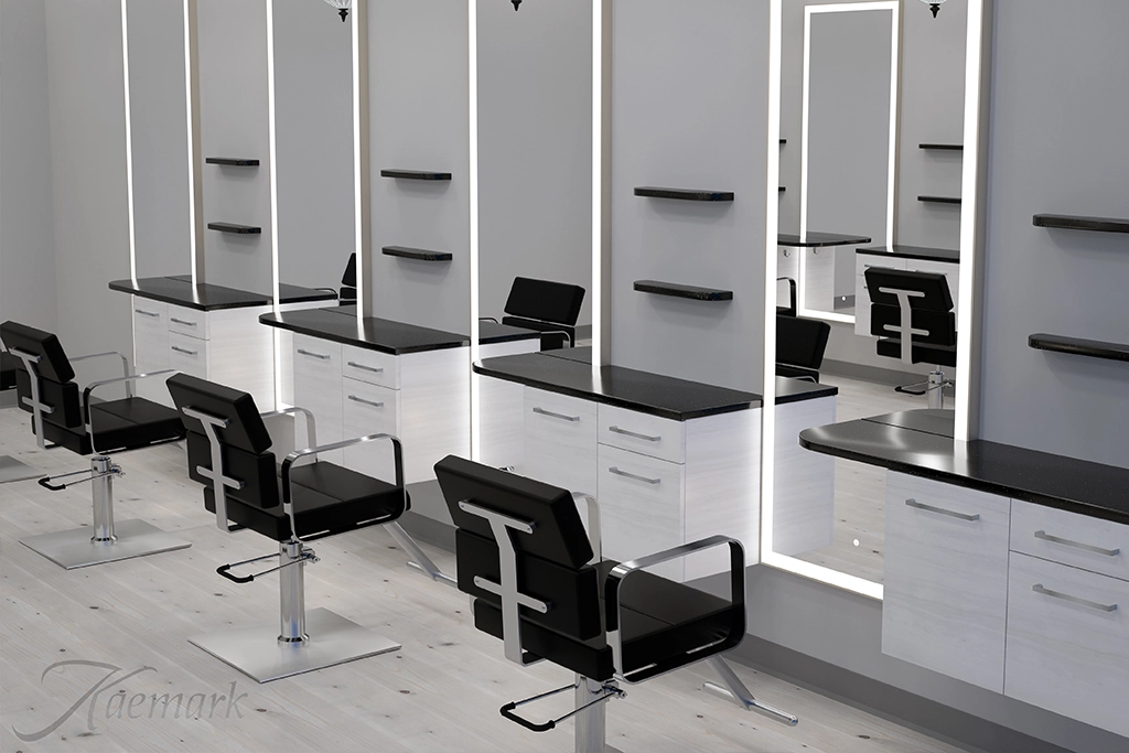 Kaemark A black and white hair salon with chairs and mirrors.