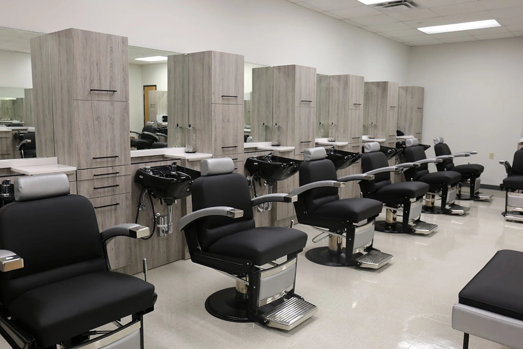 Kaemark A barber shop with black chairs and mirrors.