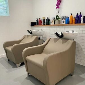 Kaemark A hair salon with two chairs and a sink.