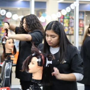Kaemark A group of women working on a mannequin in a hair salon.