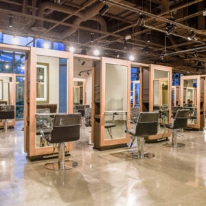 Kaemark A large salon with many chairs and mirrors.