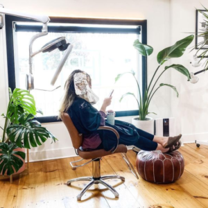 Kaemark A woman sitting in a chair in a room with plants.