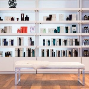 Kaemark A white bench sits in front of shelves full of hair products.