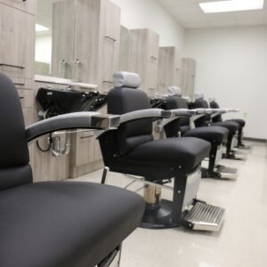 Kaemark A row of barber chairs in a room.