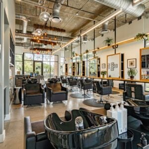 Kaemark A hair salon with a lot of chairs and tables.