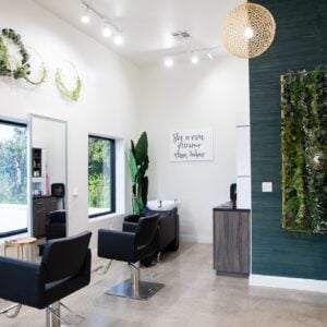 Kaemark A hair salon with a green wall and chairs.