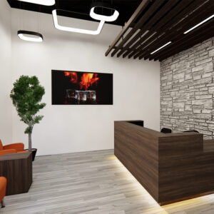 Kaemark A modern reception area with orange chairs and a stone wall.