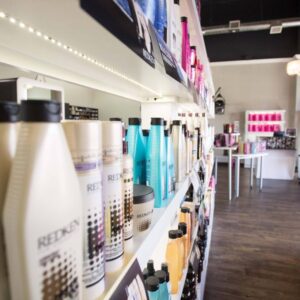 Kaemark A hair salon with shelves full of shampoos and conditioners.