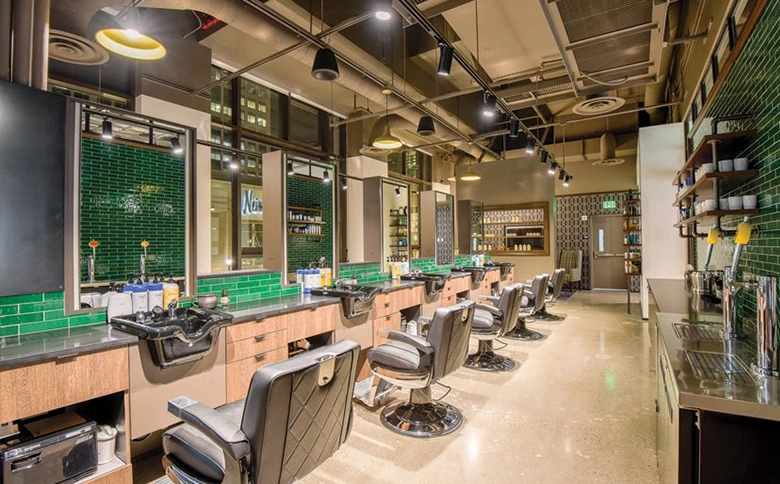 Kaemark A barber shop with green tiled walls and chairs.