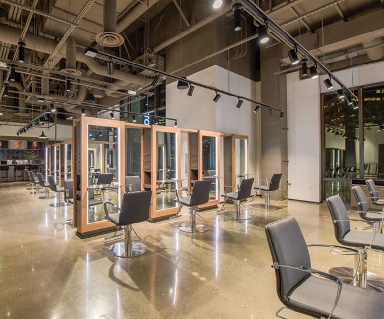 Kaemark A large hair salon with chairs and mirrors.
