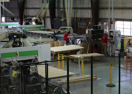 Kaemark Cnc machines in a factory with people working on them.