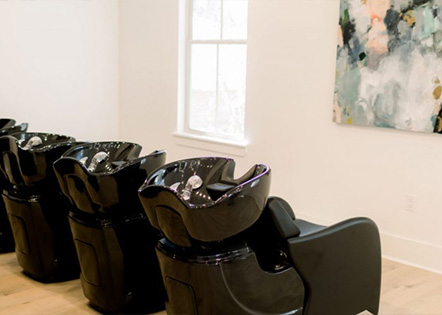 Kaemark A row of black chairs in a room with a painting.