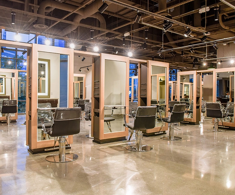 Kaemark A large salon with many chairs and mirrors.