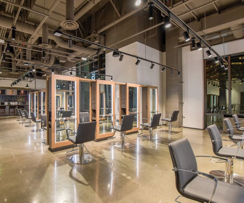 Kaemark A large hair salon with chairs and mirrors.