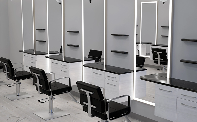 Kaemark A black and white salon with chairs and mirrors.
