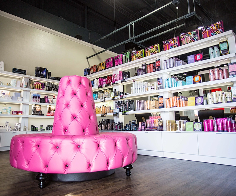 Kaemark A pink chair in a store with shelves full of products.