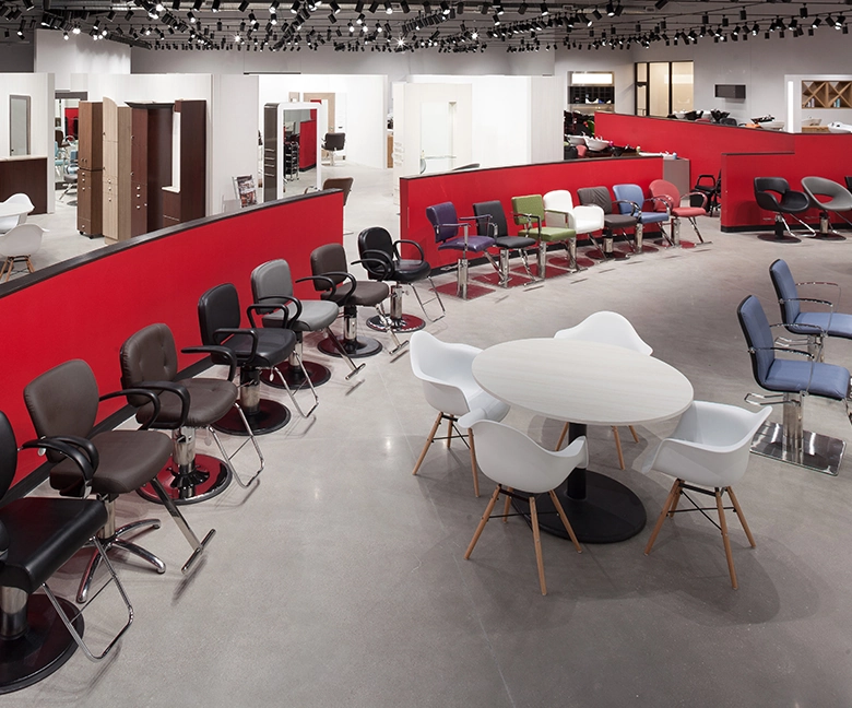 Kaemark A salon with a lot of chairs and tables.