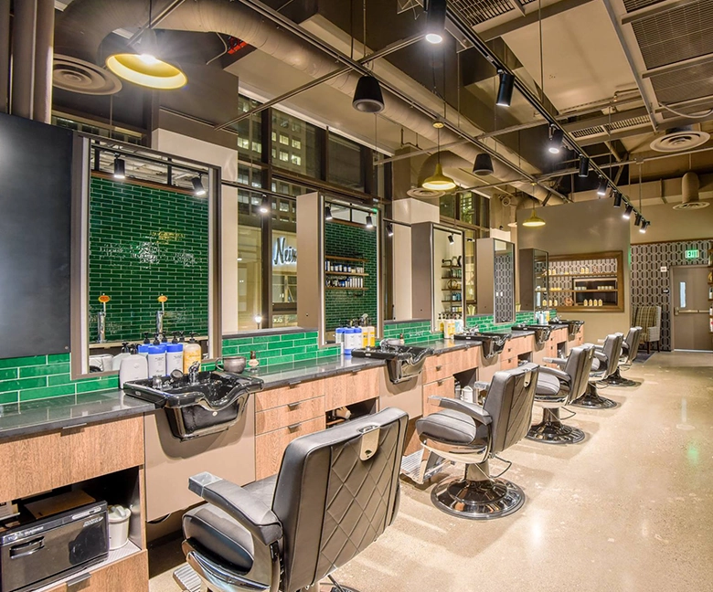 Kaemark A barber shop with green tiled walls and chairs.