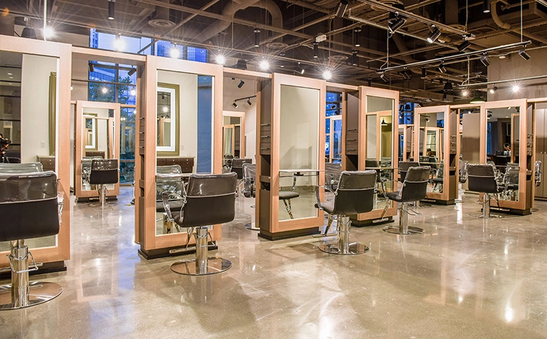 Kaemark A large salon with many chairs and mirrors.