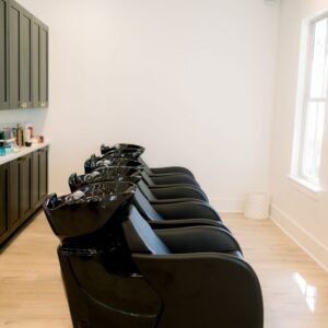 Kaemark A black hair chair in a room with wooden floors.